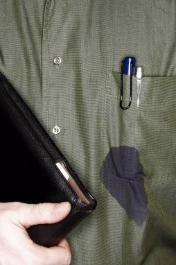 A blue ink pen leaks in the pocket of a dark green shirt.