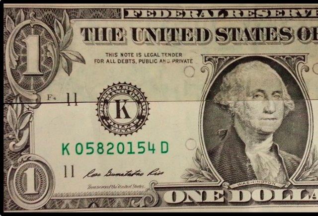 A U.S. dollar bill that has been cleaned on the bottom half but not the top half