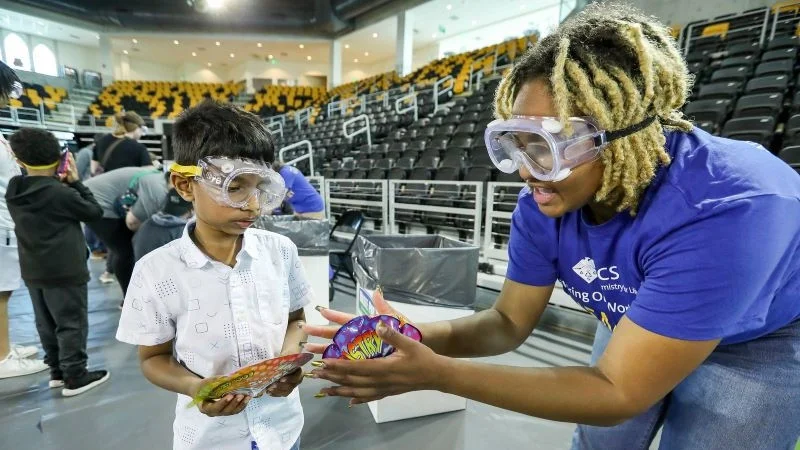 Volunteer helping a student with an experiment at an ACS Event