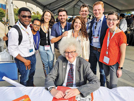 Sir Martyn Poliakoff seated with eight young people behind him.