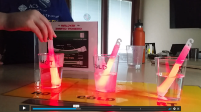 A video screenshot with three glowing glowsticks in three plastic cups with water
