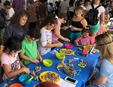 Kids and parents at a table at an outreach event