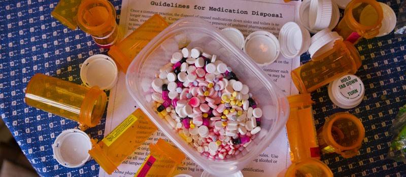 Various medicines in a container with guidelines for disposal
