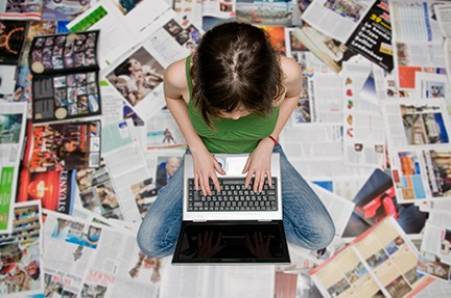girl with laptop  sitting on magazines