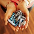 Closeup on different types of batteries held in the hand a person