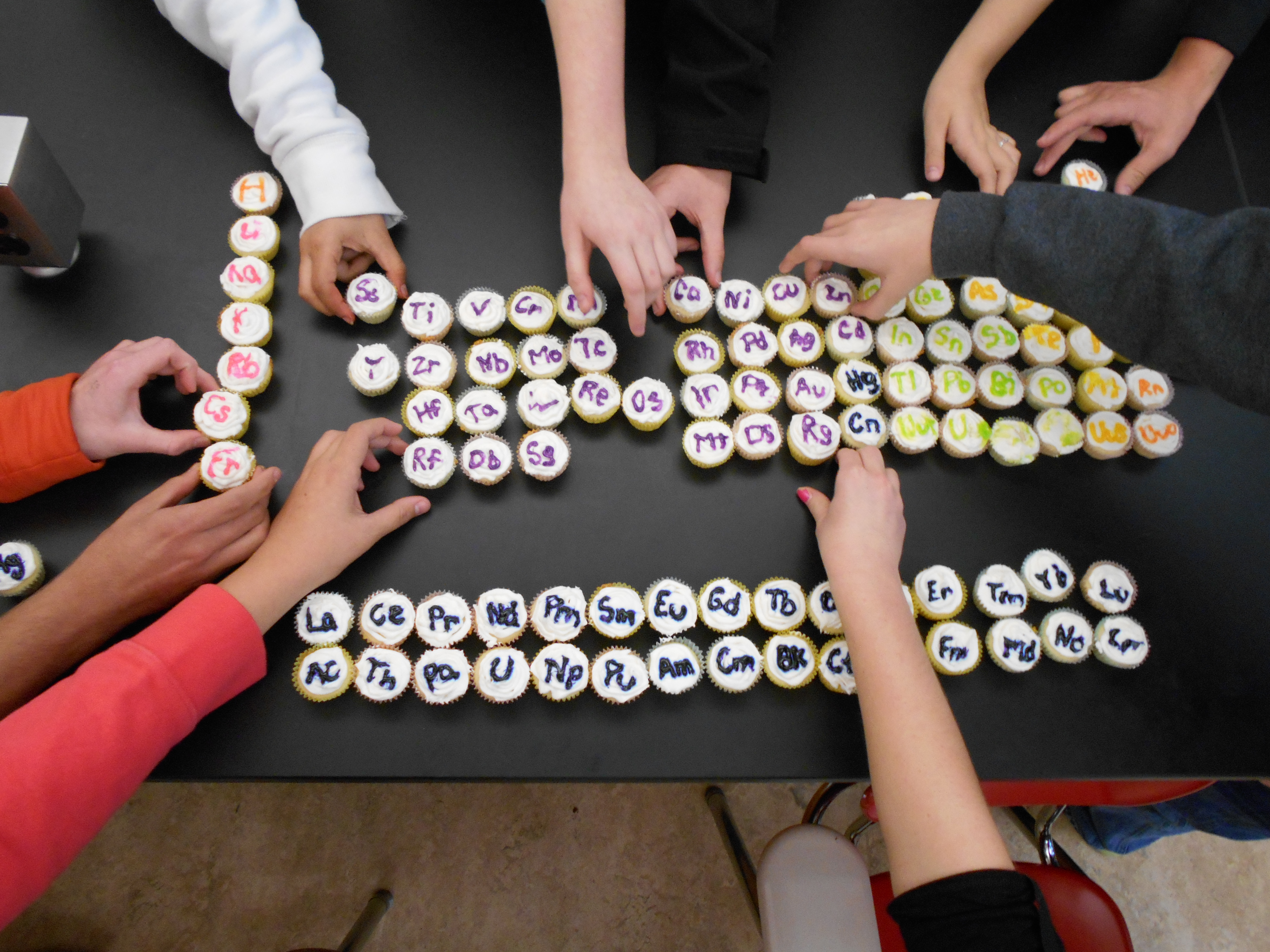 grabbing periodic table cupcakes