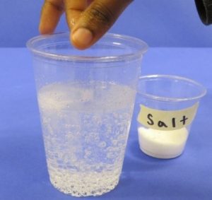 Placing salt in clear soda results in bubbling