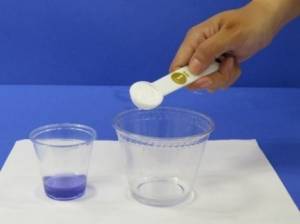 Adding tablespoon of vinegar to empty cup.