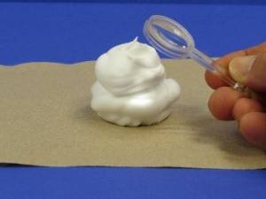 Looking at shaving cream with a magnifying glass.