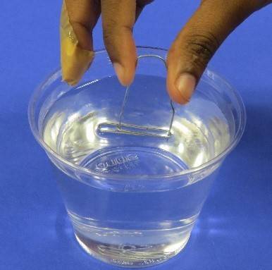 Using device to put paper clip on water