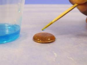 adding detergent to water on a penny