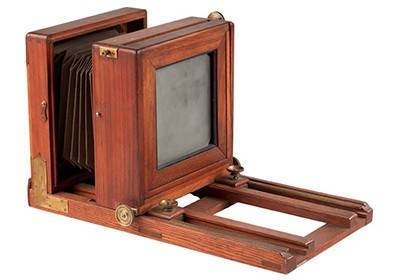 A wet plate camera, made from wood, consists of a moveable frame