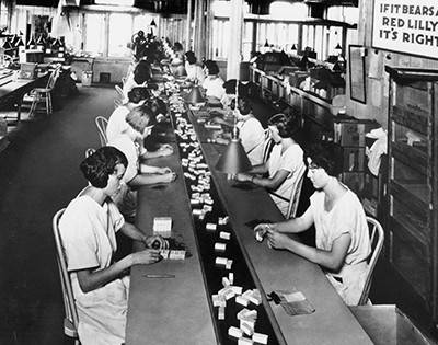 Black and white photo of workers packaging insulin.