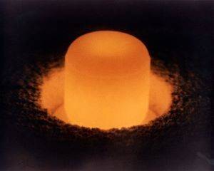 A pellet of plutonium-238 oxide glows with heat generated by its radioactive decay.