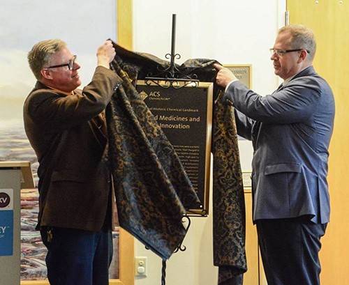 Kalamazoo Valley Museum Director Bill McElhone (left) and ACS Past-President Peter Dorhout unveil the Landmark plaque at the designation ceremony.