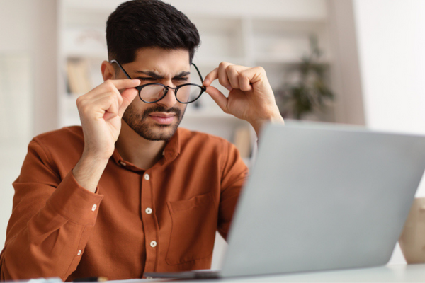 Man with blurry vision looking at computer screen