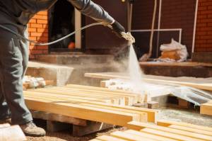 Wood being sprayed with boron acid to make it less flammable