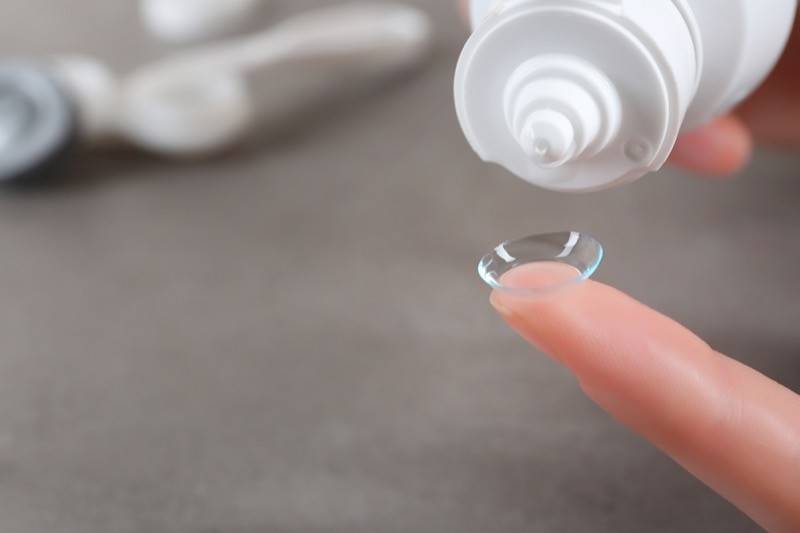 Contact lens solution being poured onto a contact lens