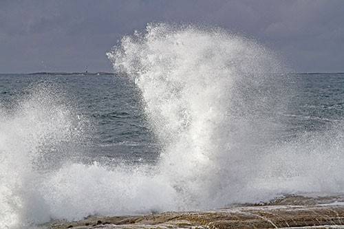 sea spray from wave crashing into coast