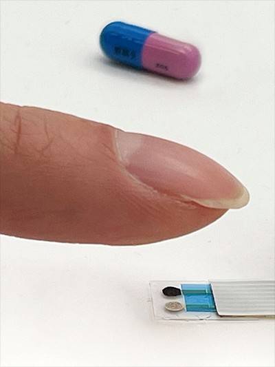 A fingertip hovers above a small sensor