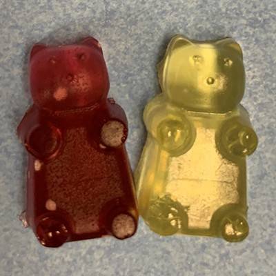 Two gummy bears, one red on the left, one yellow on the right