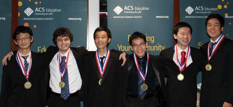 Six high school students wearing suits, each with a medal around their necks