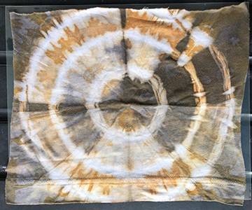 A piece of tie dyed fabric in a bullseye pattern