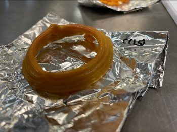 Three circles of an orange-brown material are stacked together on a folded piece of aluminum foil