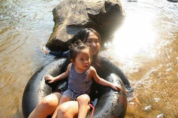 Woman and child tubing in water.