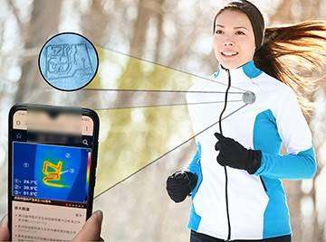 A woman wearing cold weather running gear mid-stride, a superimposed cellphone zooms in on superimposed ink on her jacket