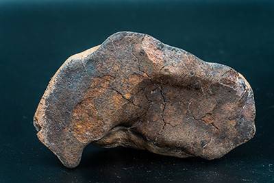 Close up of chondrite meteorite, an orange and grey rock