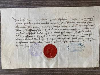 An old, paper letter, featuring script-style writing in Latin, a red wax seal and two blue stamps.