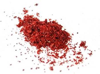 A pile of shiny, bright red shavings sit on a white background