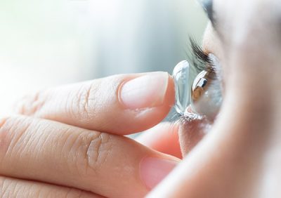 Woman putting a contact lens onto her eye