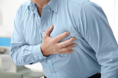 A person grasping the left side of their chest.