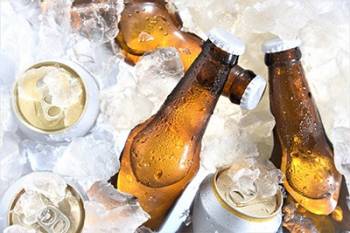 Cans and brown bottles nestled in ice cubes