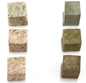 Six cubed rock samples, three of granite and three of soapstone. Their colors vary from light to dark shades of grey and brown.