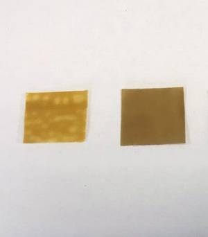 A square piece of golden film sitting next to a square piece of brown film.