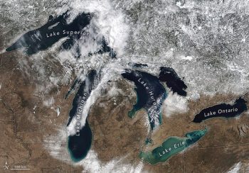 An aerial view of the Great Lakes, each labelled, with a 100-kilometer scale bar. 